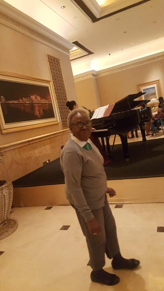 Margaret standing beside a grand piano
